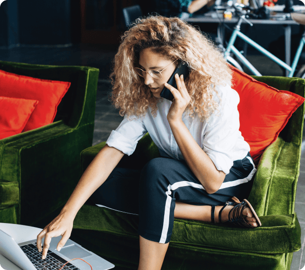 woman on phone using laptop