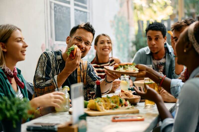 Group of friends enjoying a meal out together, celebrating after a personal loan funded quickly and on time