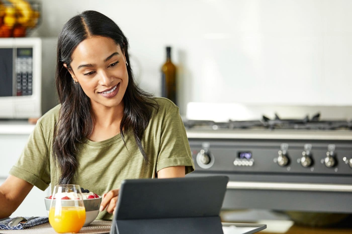 Woman looking at a laptop on her kitchen table.