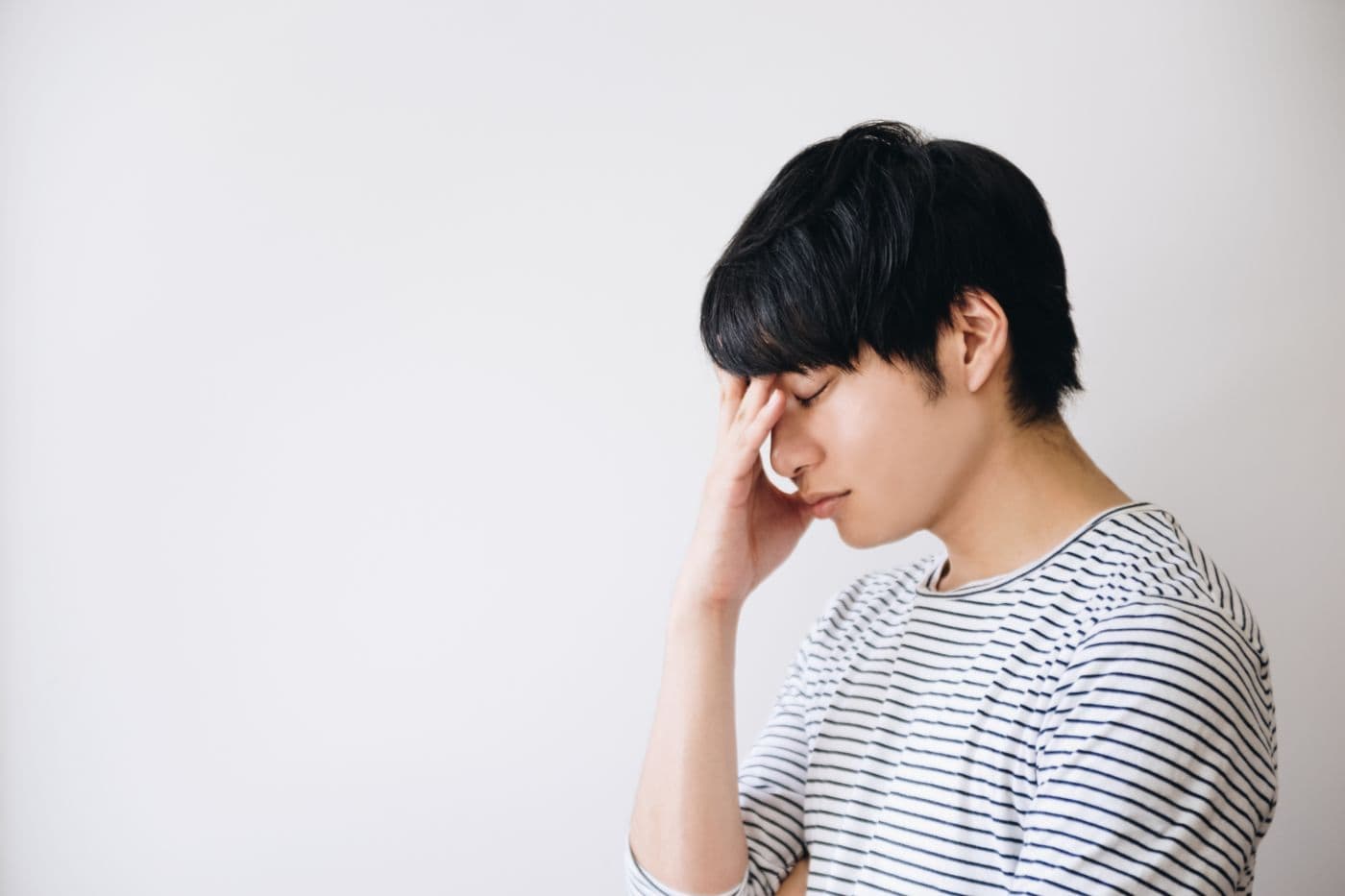 Frustrated man with his hand touching his face.